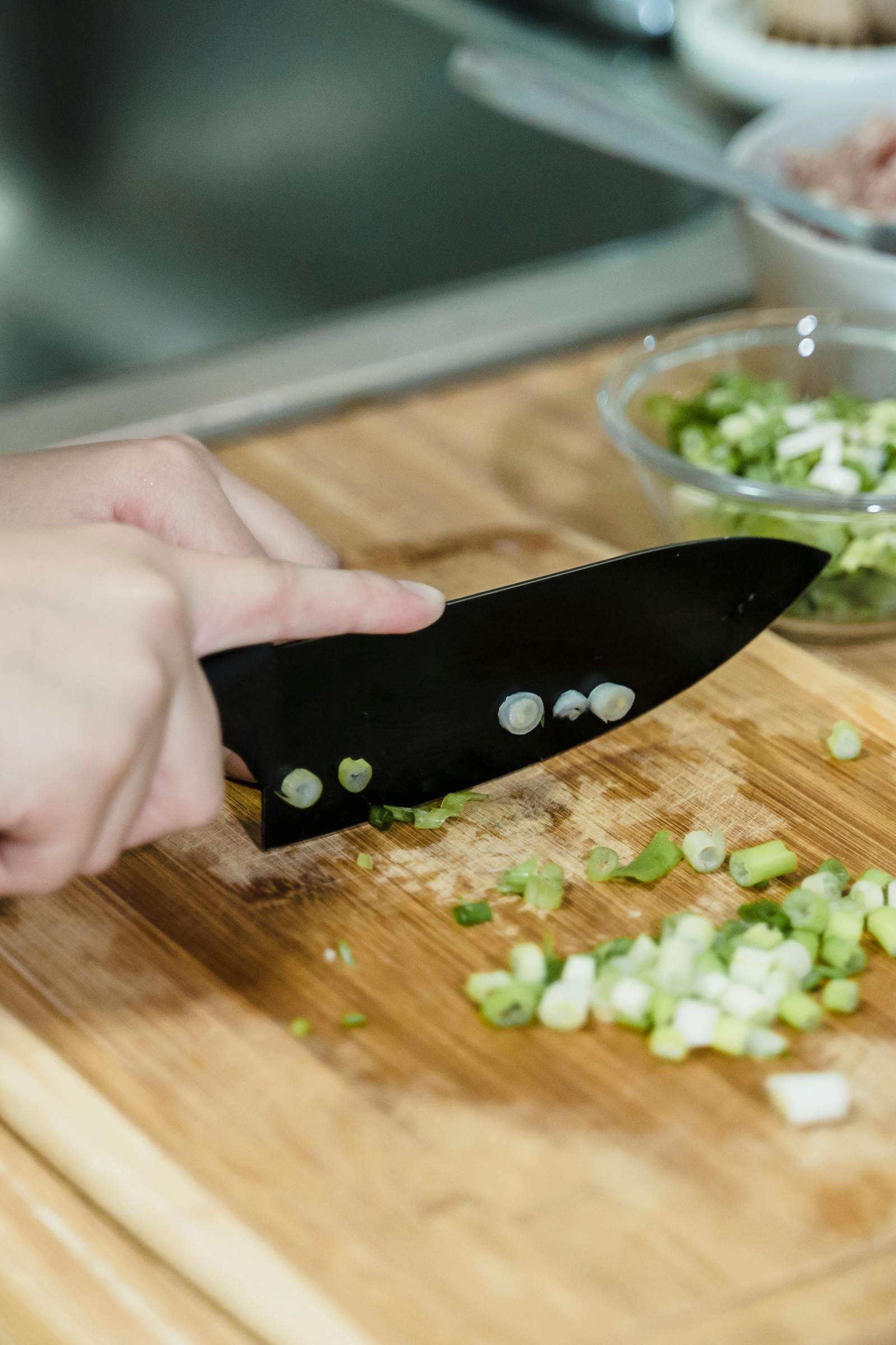 包丁で野菜を切る女性の手